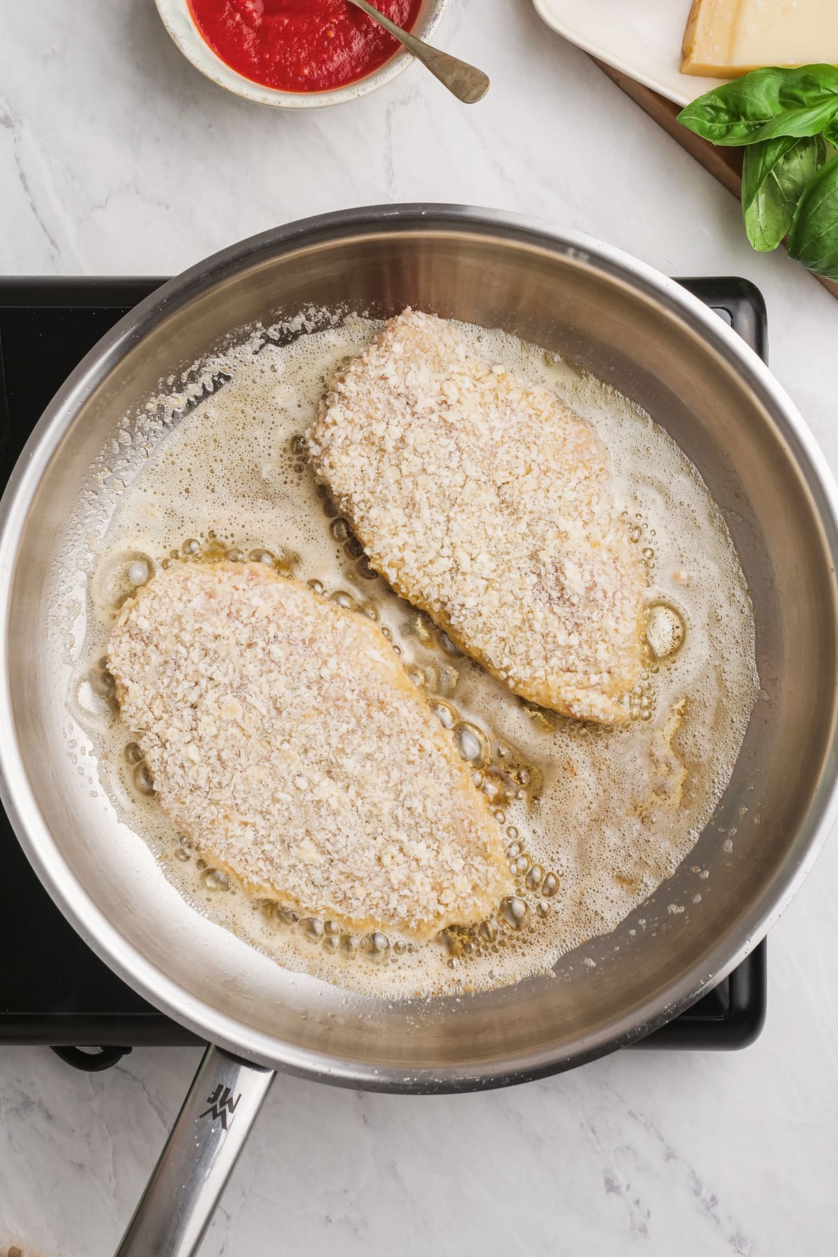 chicken breast frying in a hot skillet