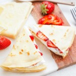 strawberry and whipped cream crepes on a tablescape