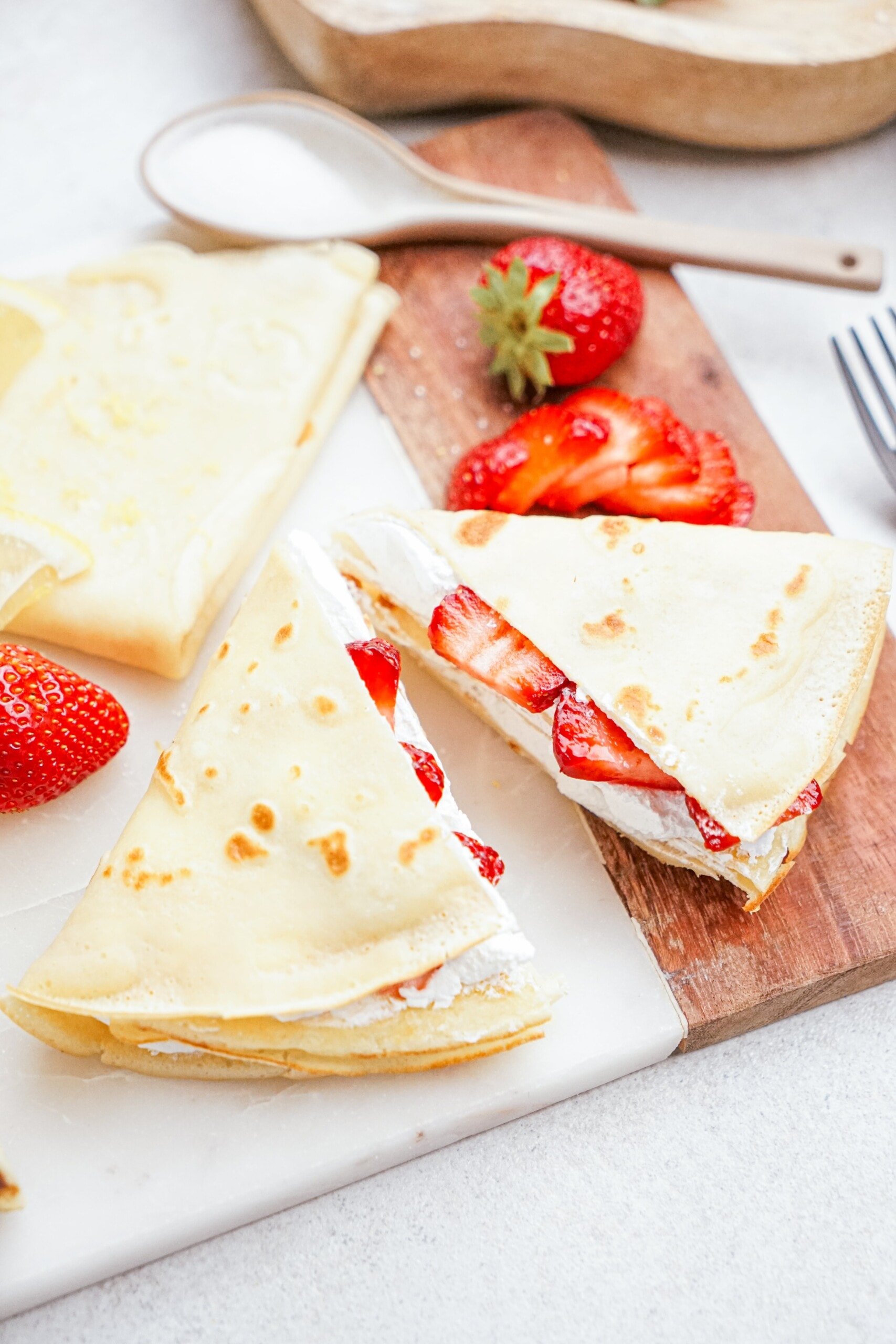 strawberry and whipped cream crepes on a tablescape