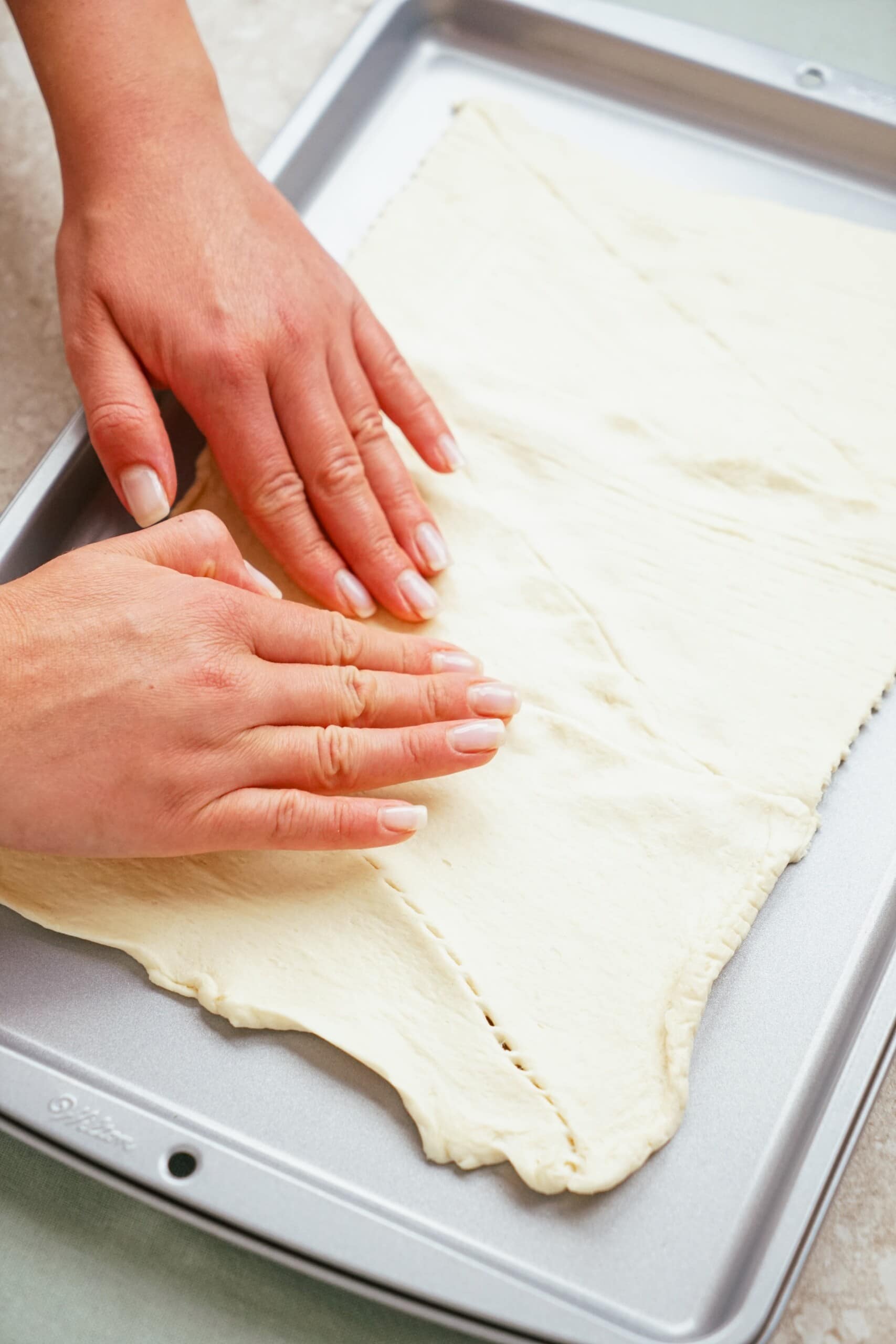 woman's hands pressing the dotted edges together