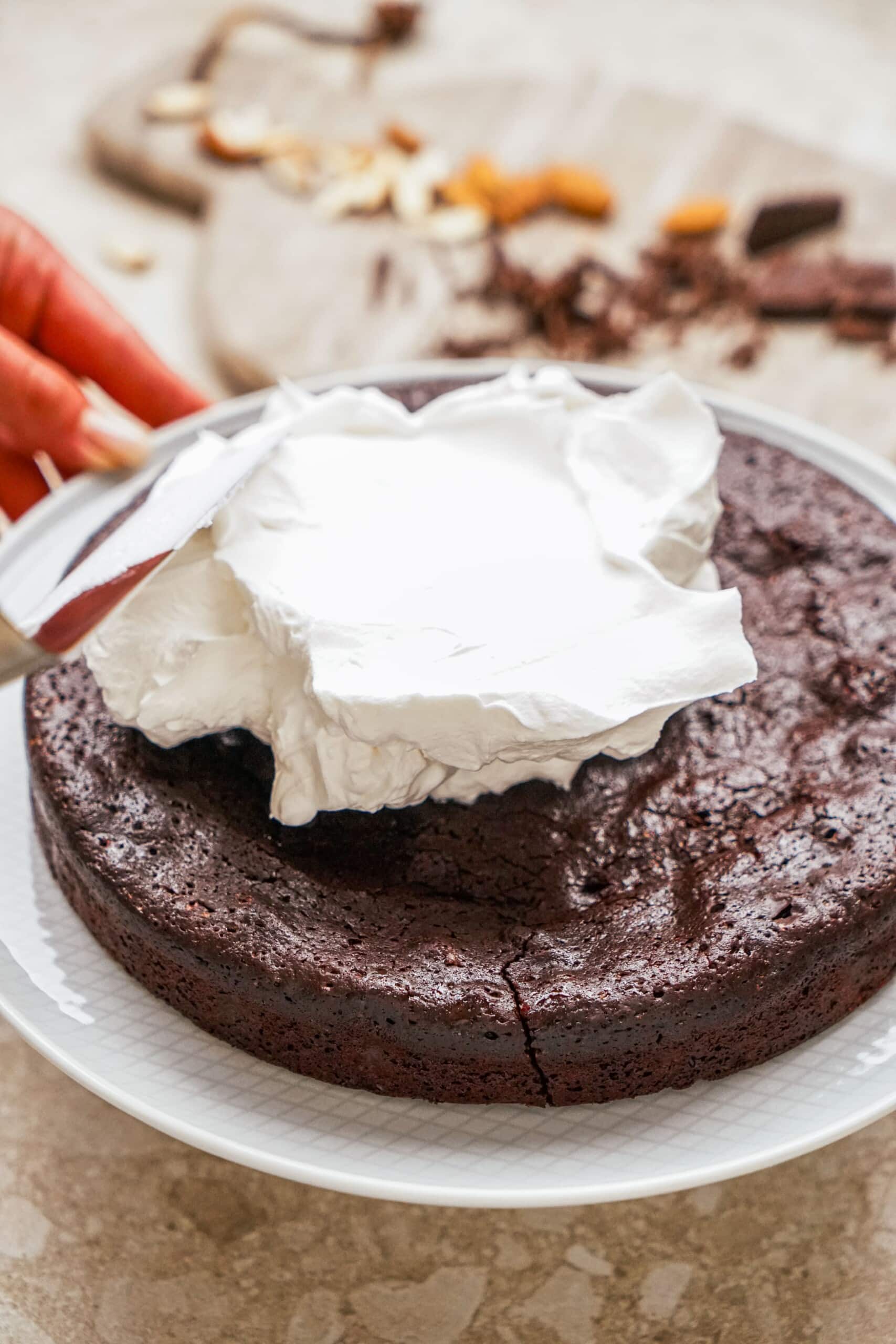 whipped cream being spread on cake
