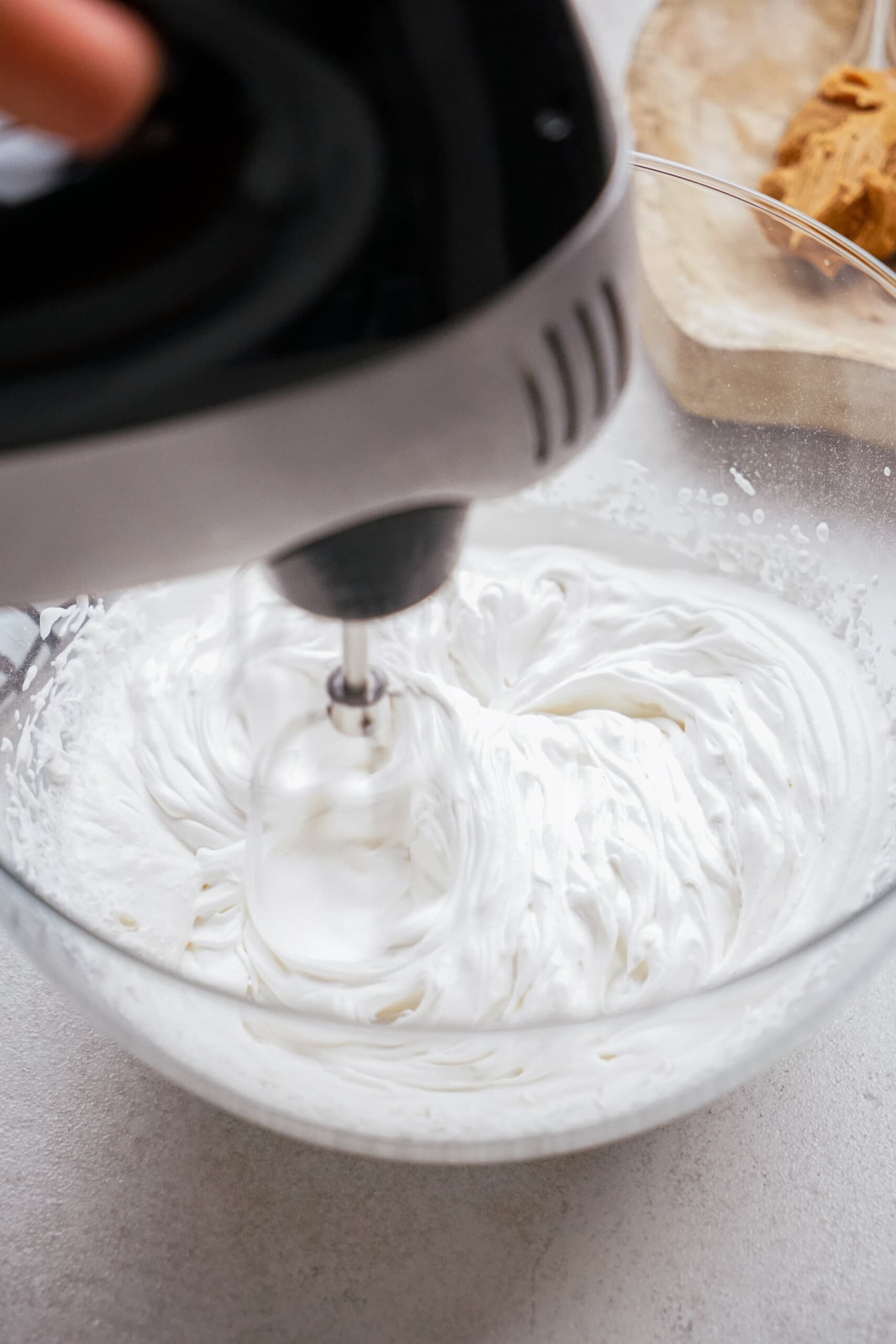 whipped cream being whisked with a hand mixer