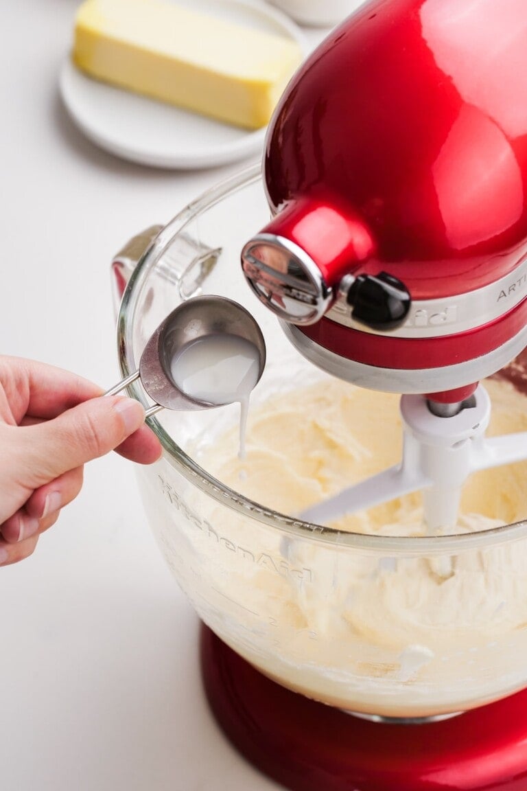 adding milk to the frosting in the stand mixer
