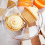 orange cupcakes on a clear glass plate- one cupcake on its side