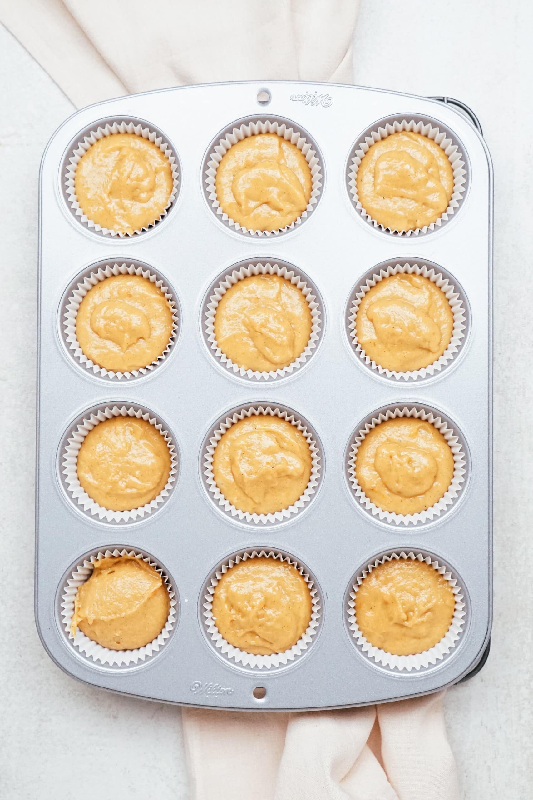 sweet potato cupcake batter in muffin tins
