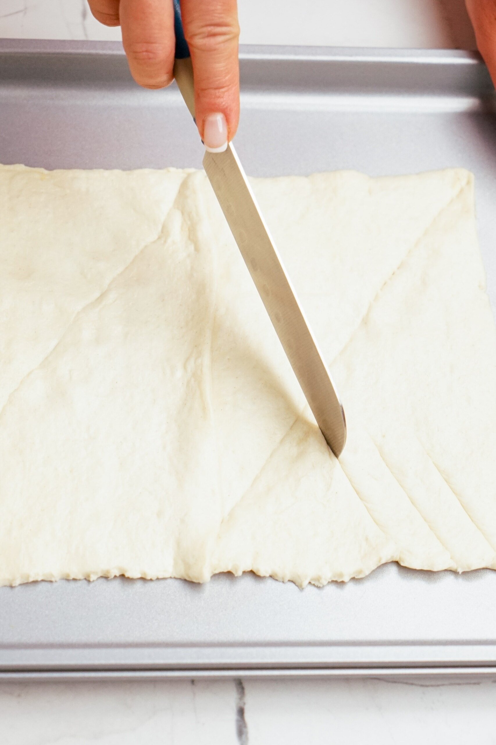 cutting diagonal lines into the crescent roll dough