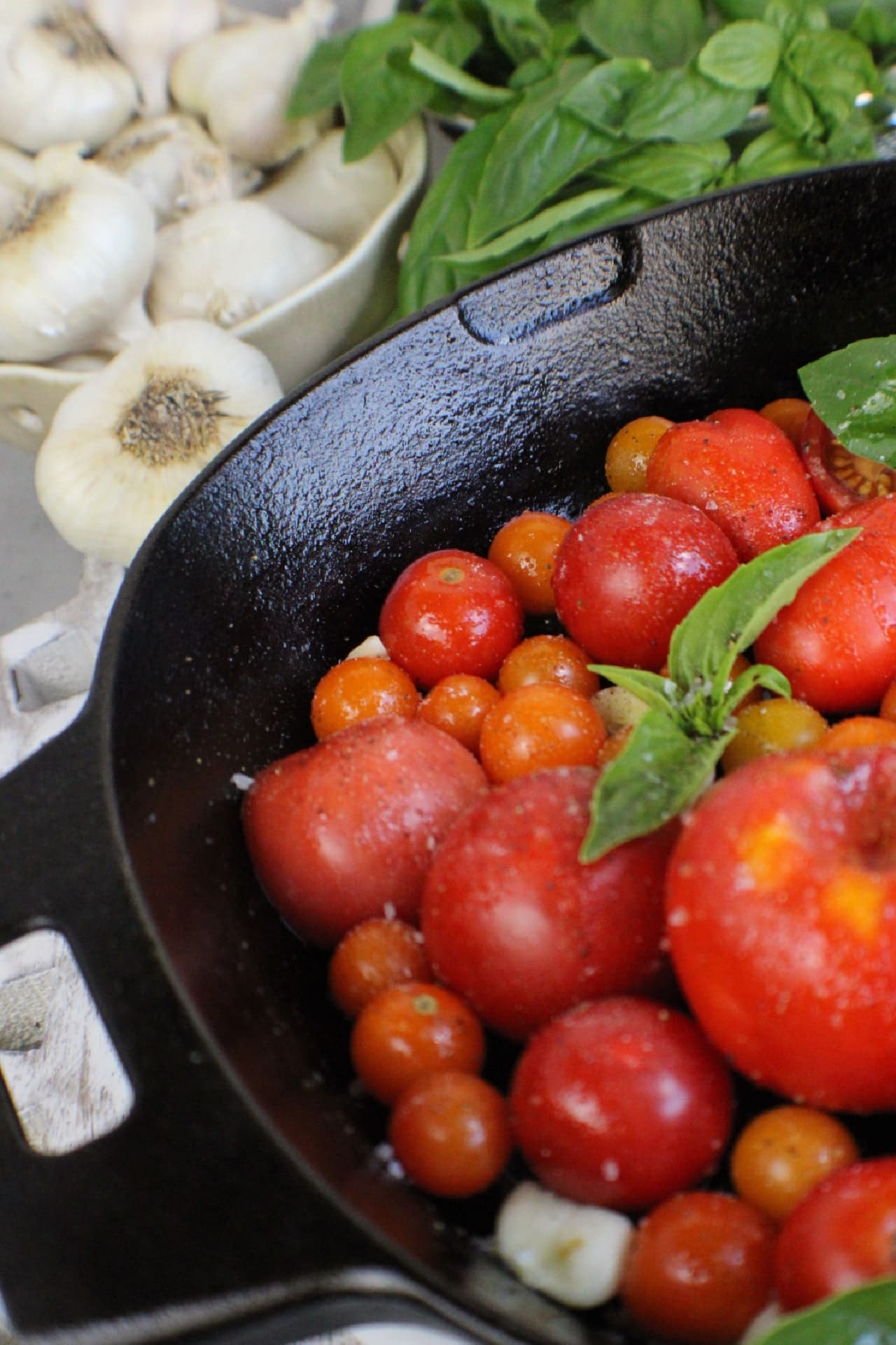 fresh tomatoes and basil in a cast iron skillet