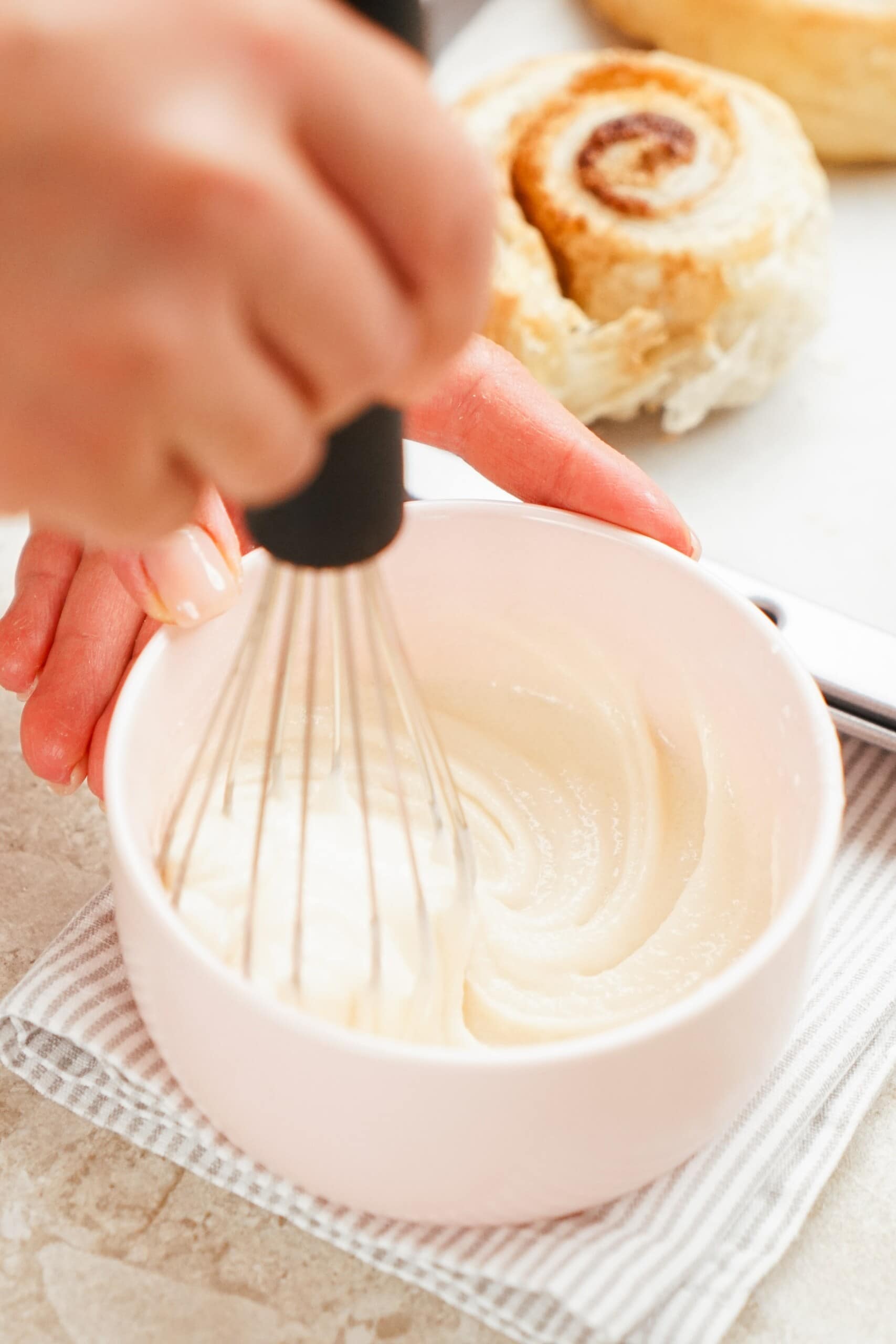 woman's hand whisking icing in bowl