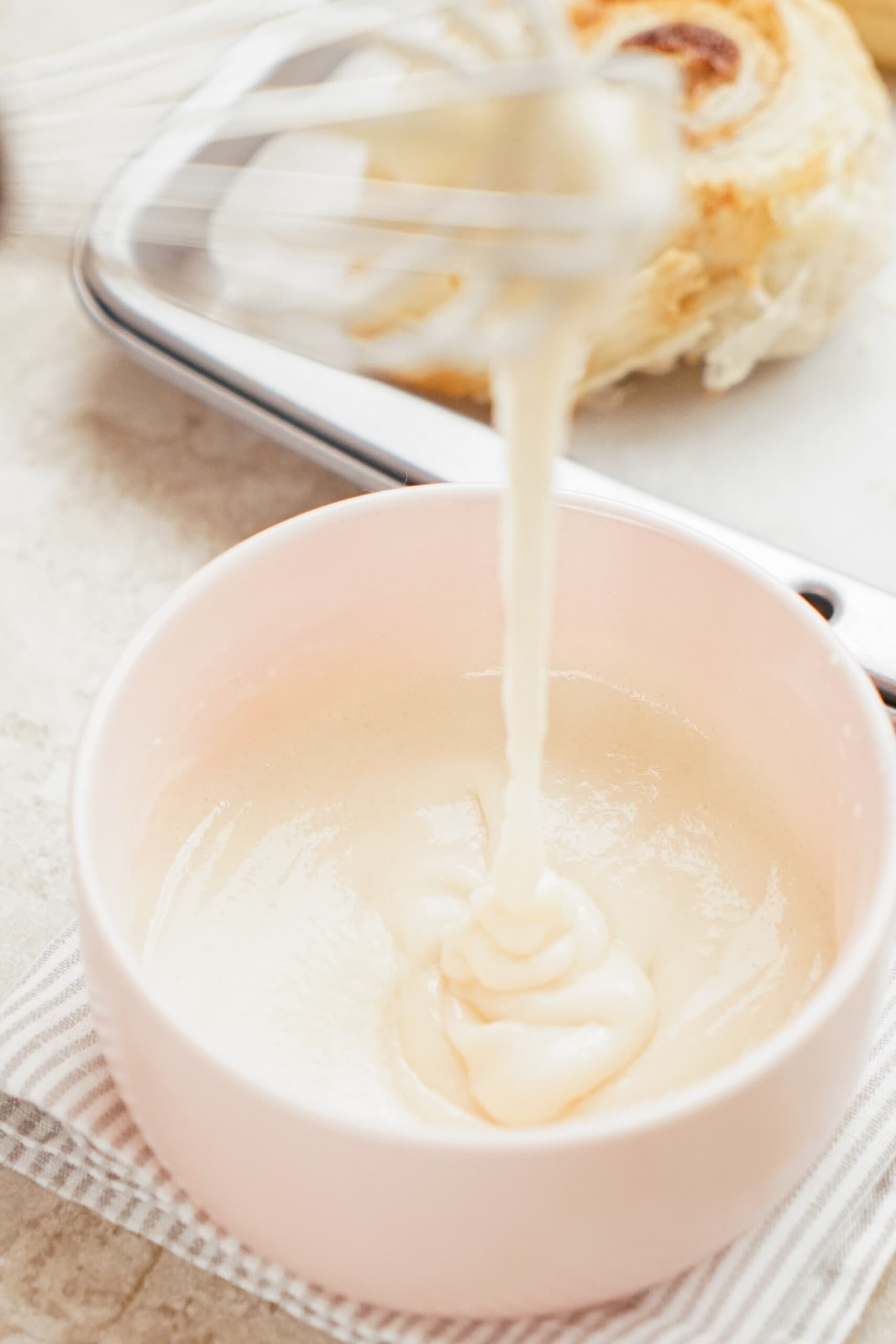 icing dripping off whisk into a bowl