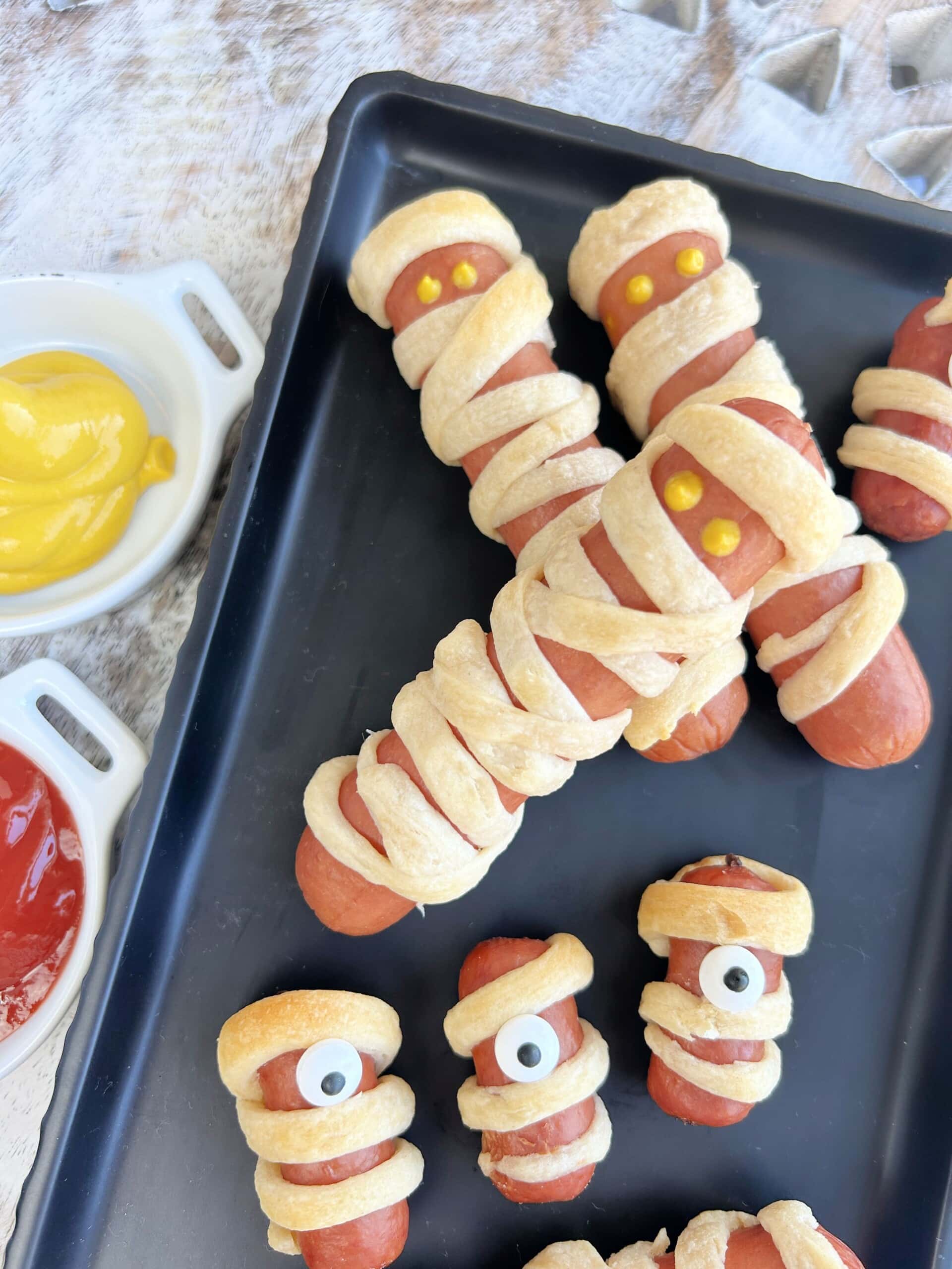 Mummy Dogs on platter with ketchup and mustard