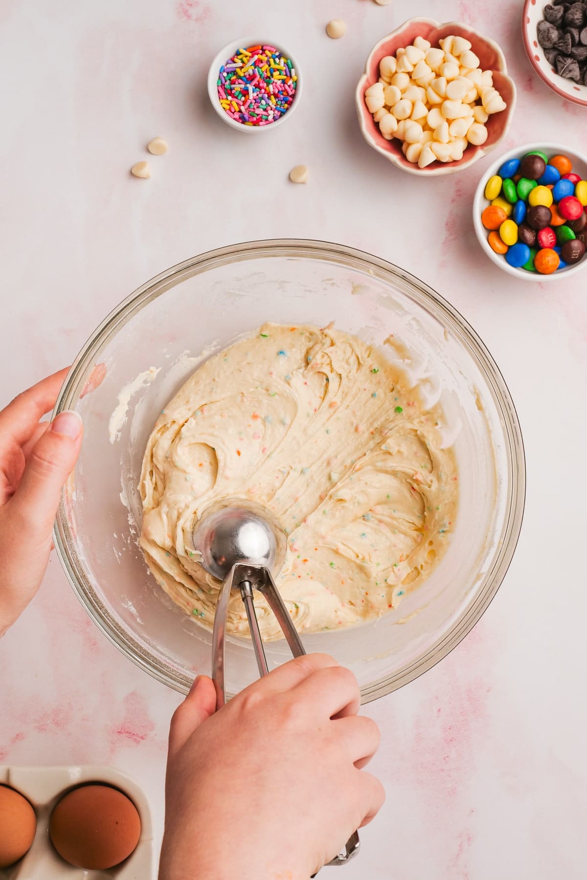 woman's hand using a cookie scoop to scoop cookie dough