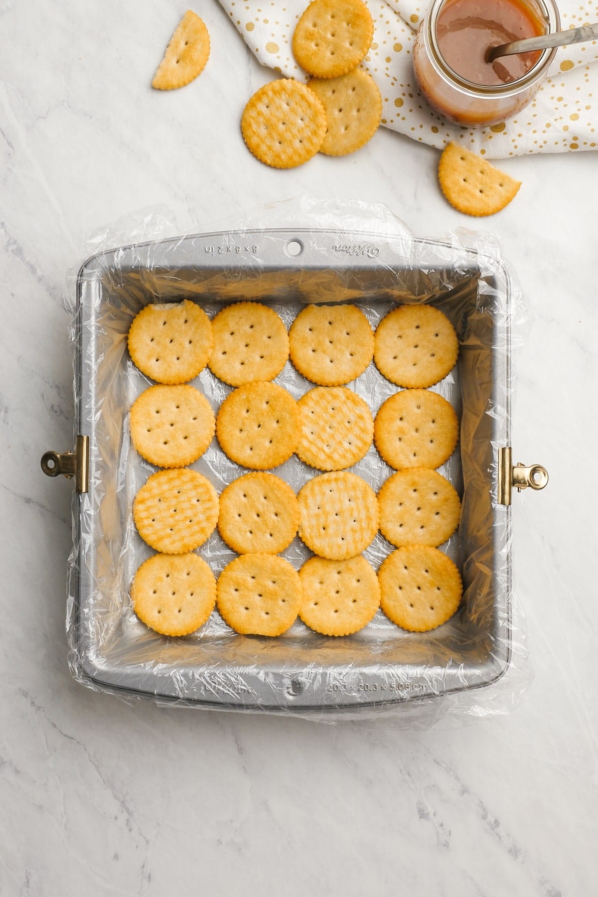 ritz crackers laid out in rows in a baking dish 