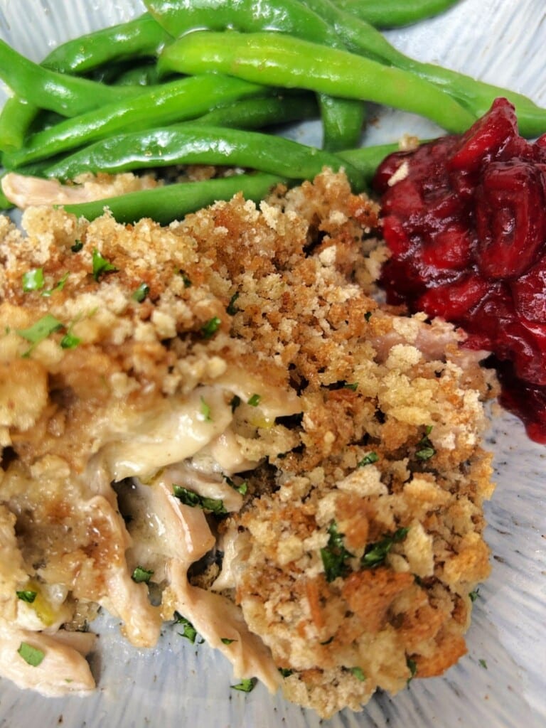 Chicken Stuffing Casserole on a plate with green beans and cranberry sauce