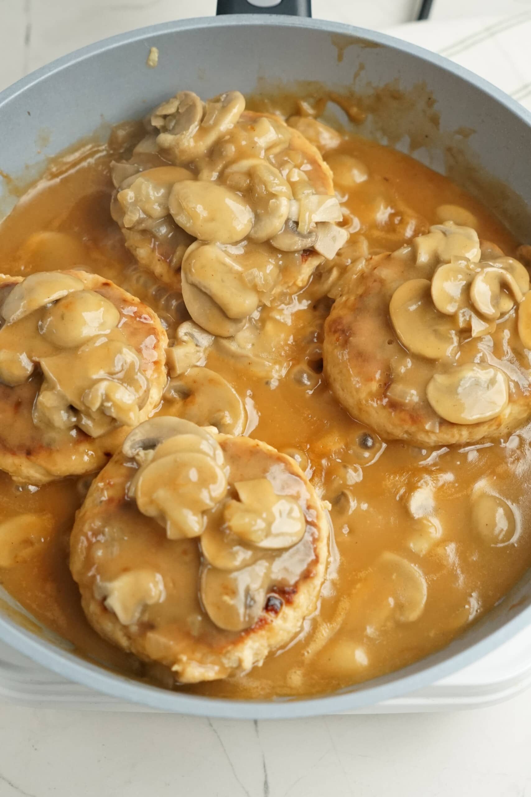 salisbury steak with mushrooms and gravy in a skillet