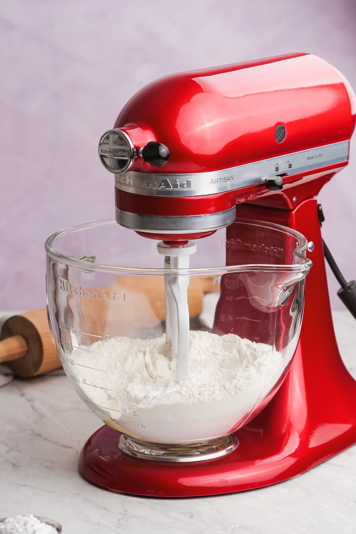 cookie ingredients in a glass stand mixer bowl with paddle attachment