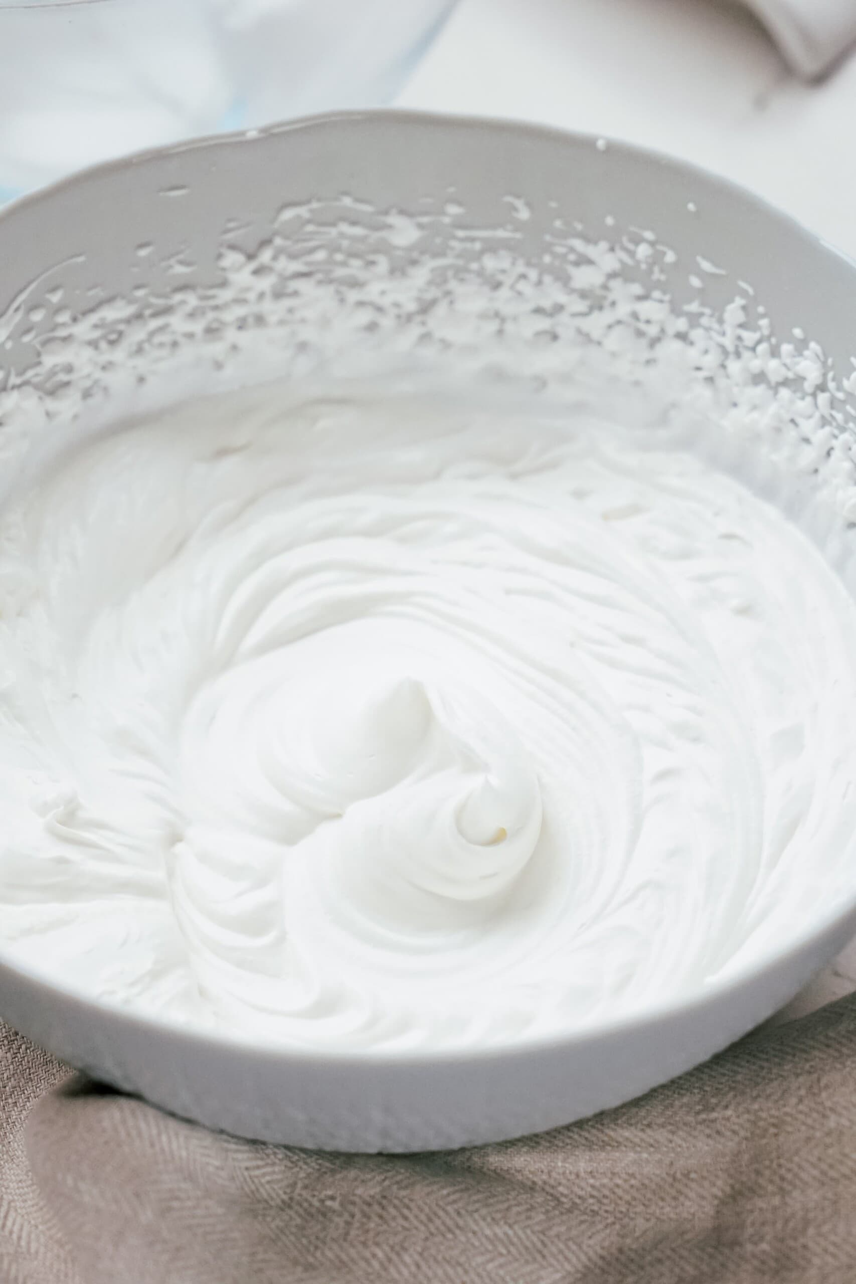 homemade whipped cream in a glass mixing bowl