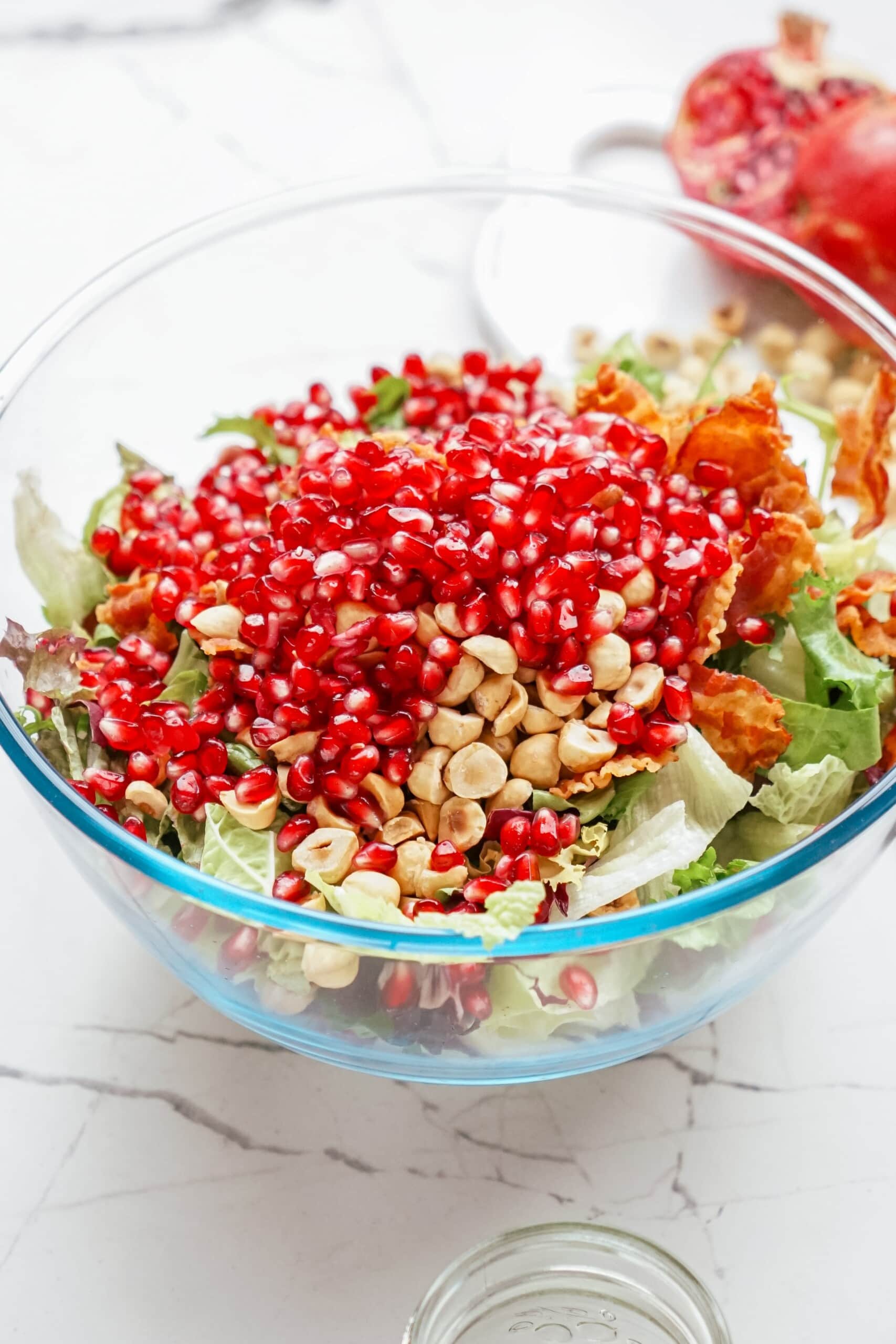pomegranate added to the salad mixing bowl