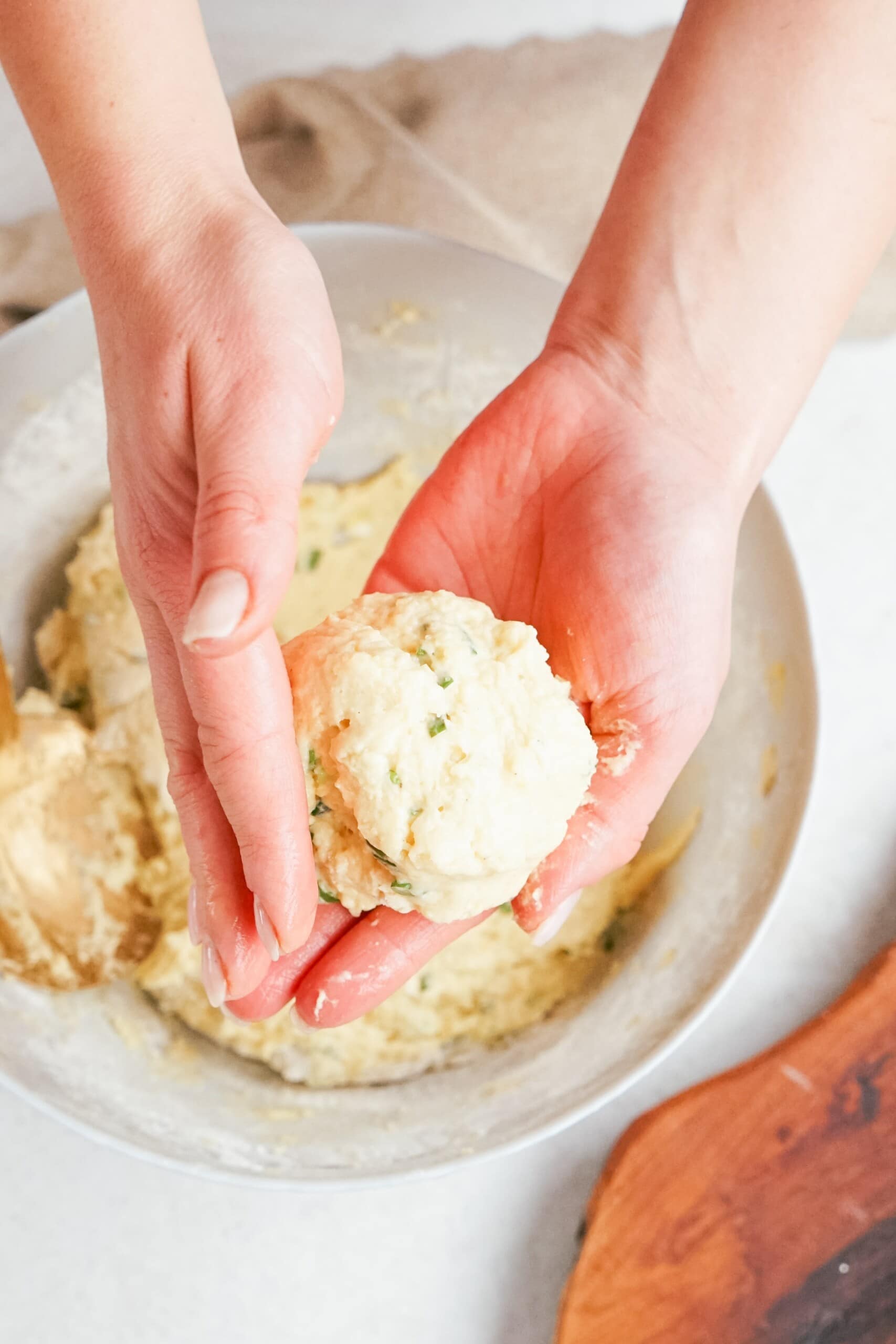 womans hands forming a ball with mashed potatoes