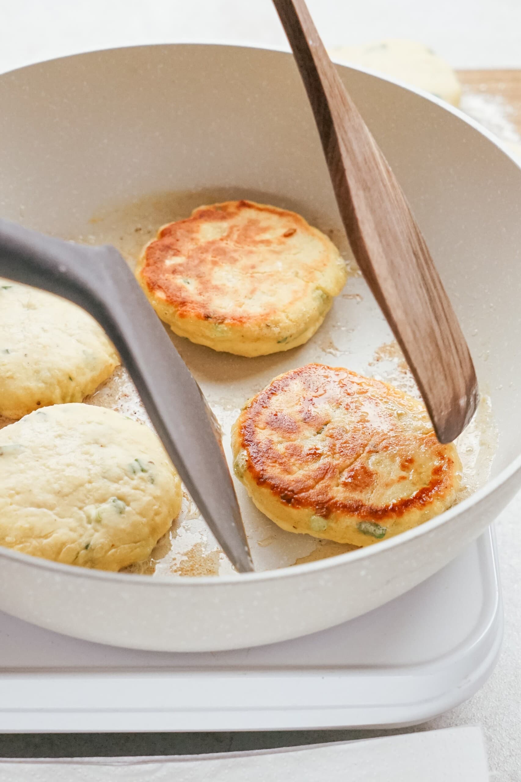 gently flipping over potato patties in the skillet