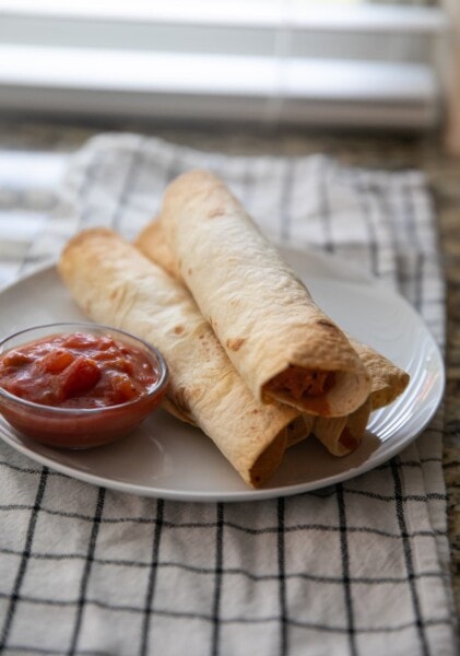 chicken taquitos on plate with salsa