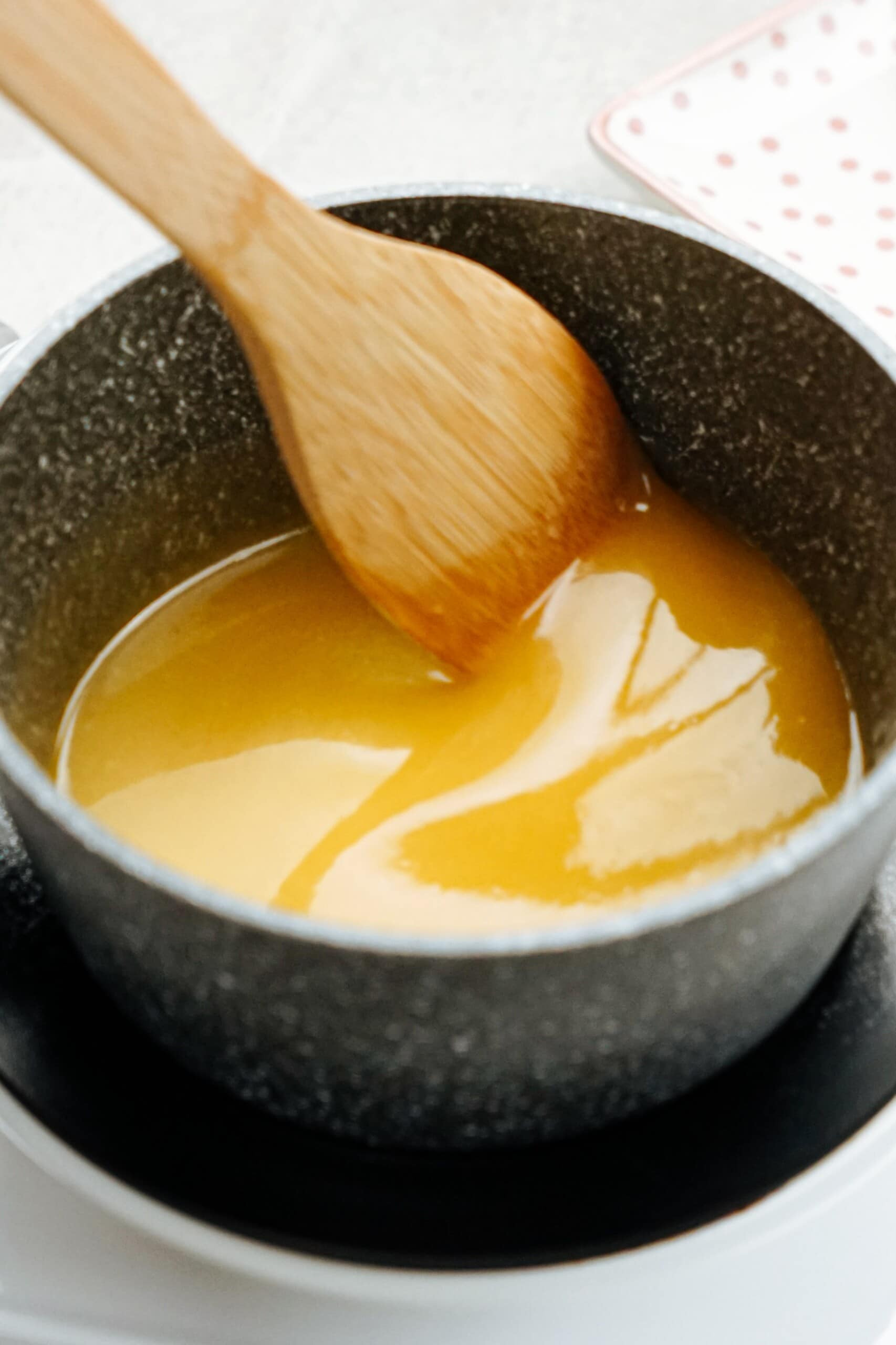 lemon glaze in a sauce pan with wooden spoon