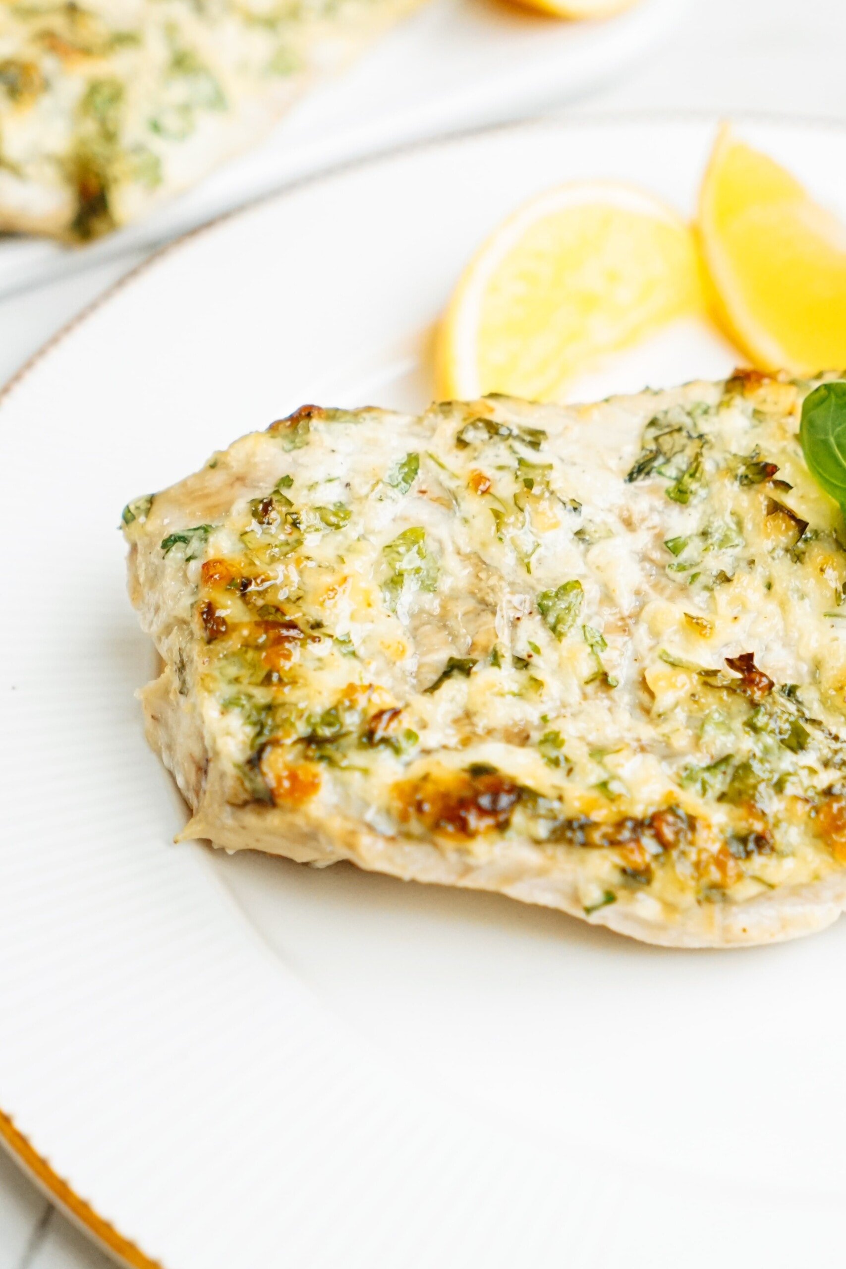 parmesan baked cod on a plate with lemon 