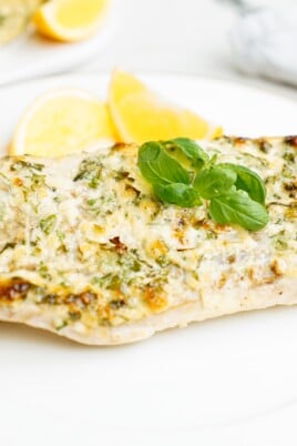 parmesan baked cod on plate with lemon wedges