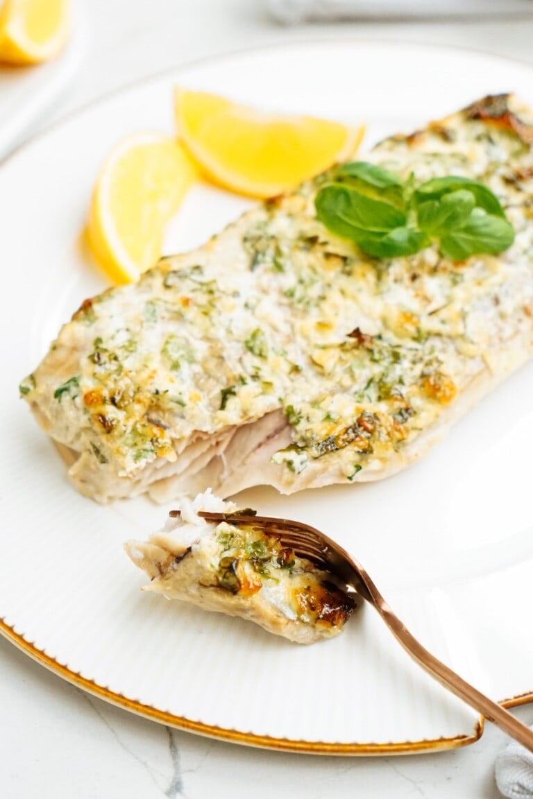 baked cod with a bite taken with a gold fork