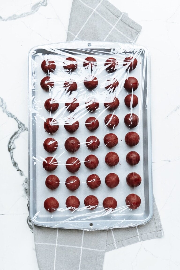 cake balls on a sheet pan covered with plastic wrap