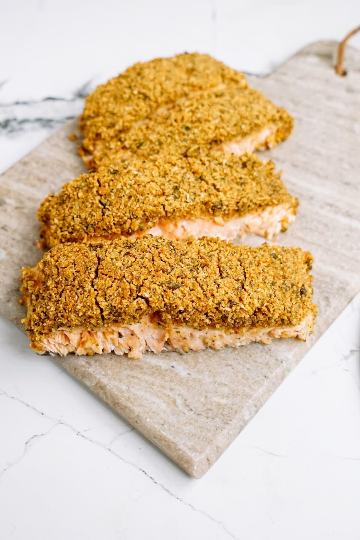 baked salmon fillets on a cutting board 