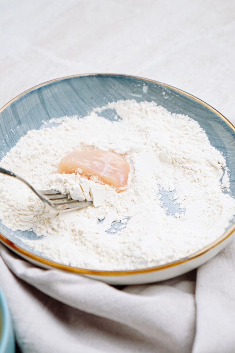 A plate with flour and a fork on it.