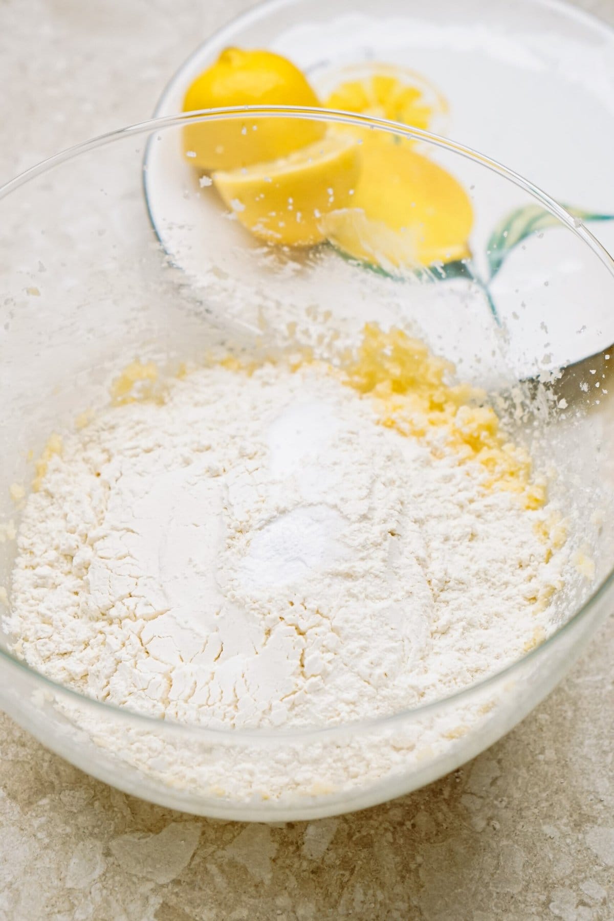 Baking ingredients with flour and eggs in a glass mixing bowl.