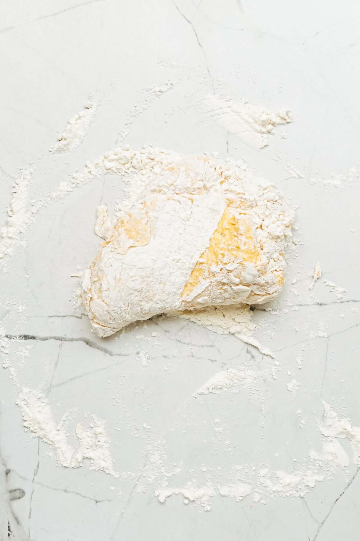 A piece of dough on a marble countertop.