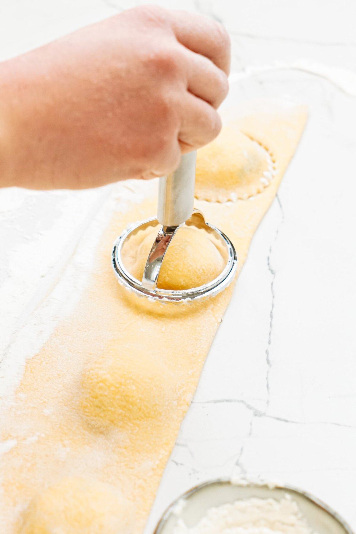 A person using a ravioli cutter to make ravioli.