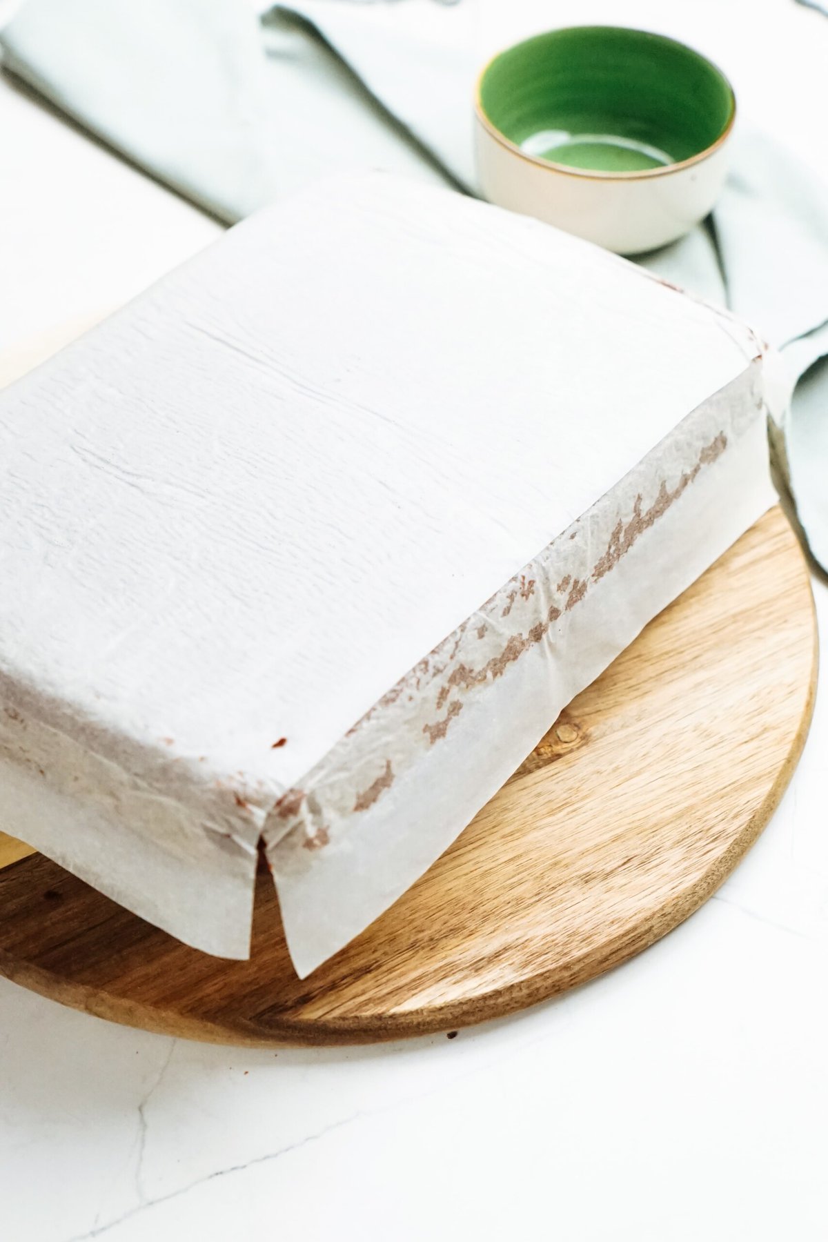 An inverted cake sitting on a wooden cutting board.