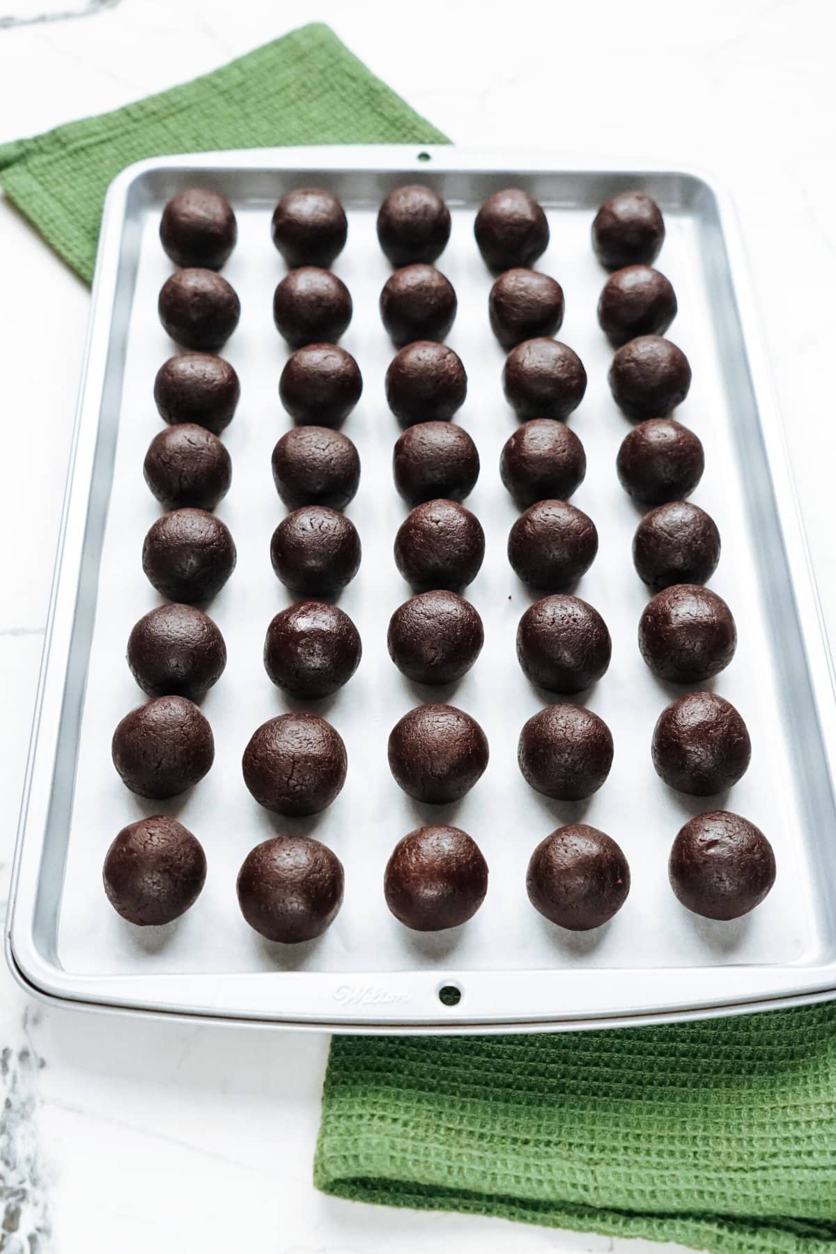 Chocolate truffles on a baking sheet.
