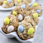 A plate of Rice Krispie Treats decorated with pastel-colored candy eggs.