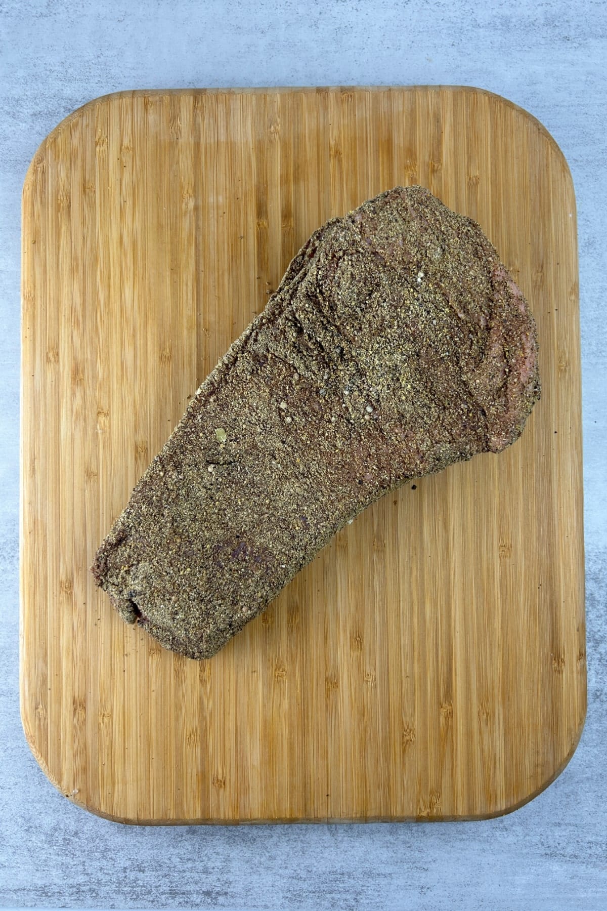 A cut of corned beef piece on a wooden cutting board.