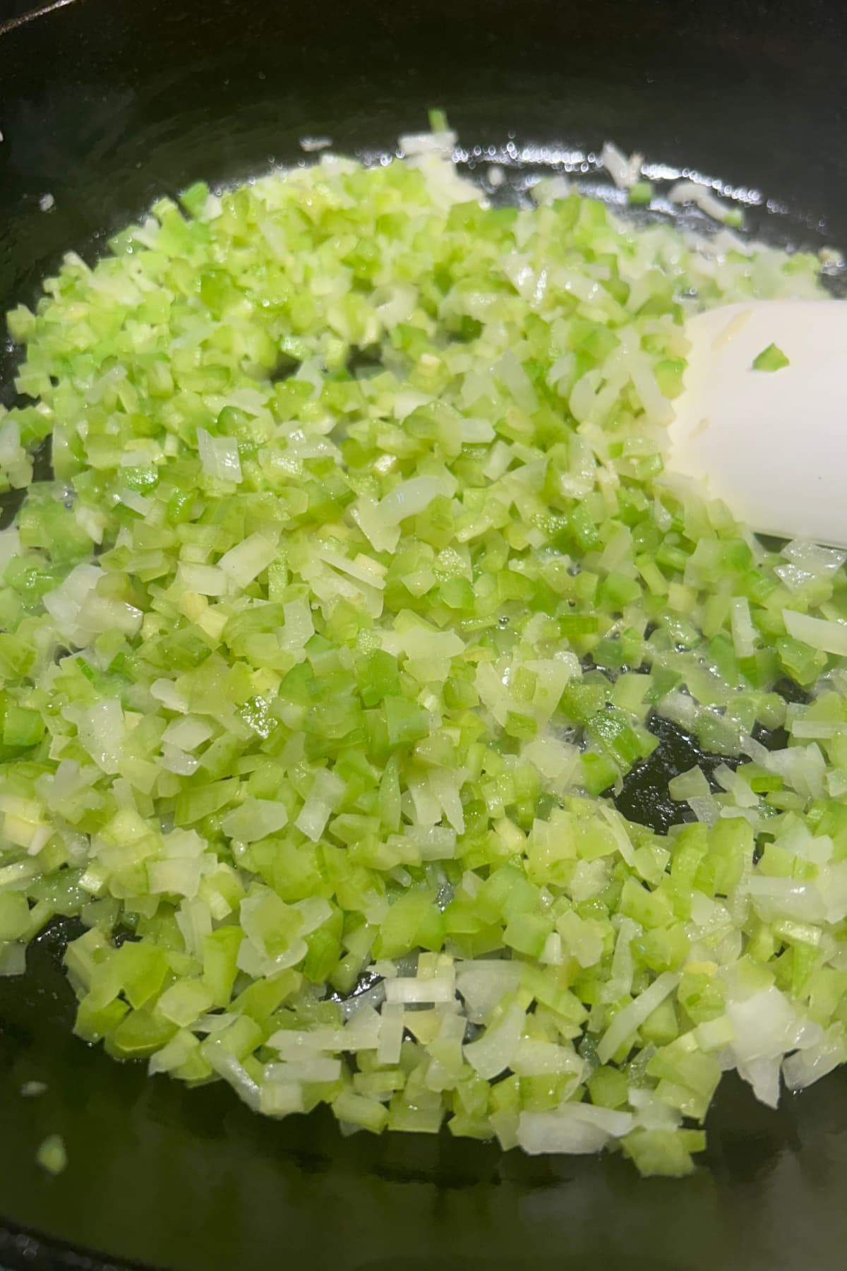celery and onions sautéing in a pan 