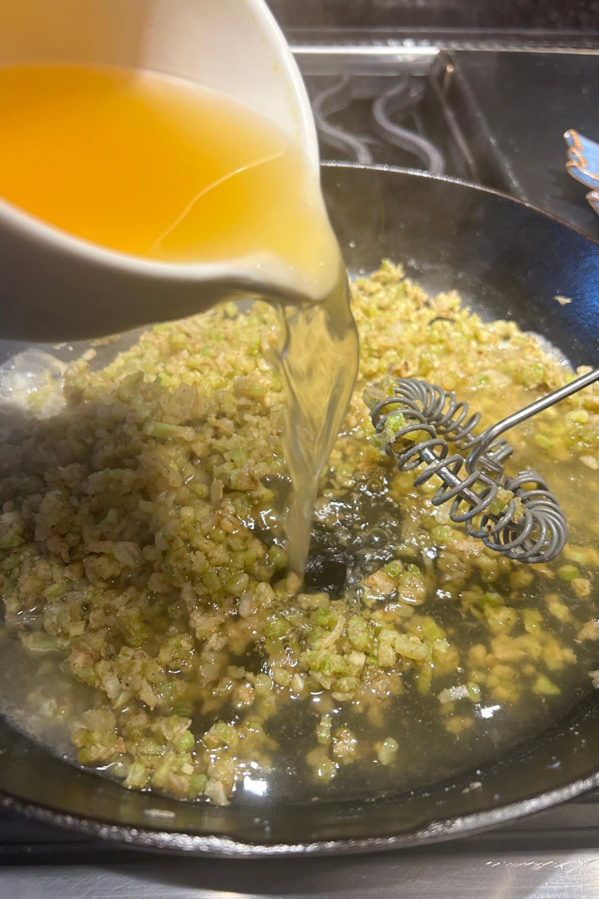 adding chicken broth to the roux mixture 