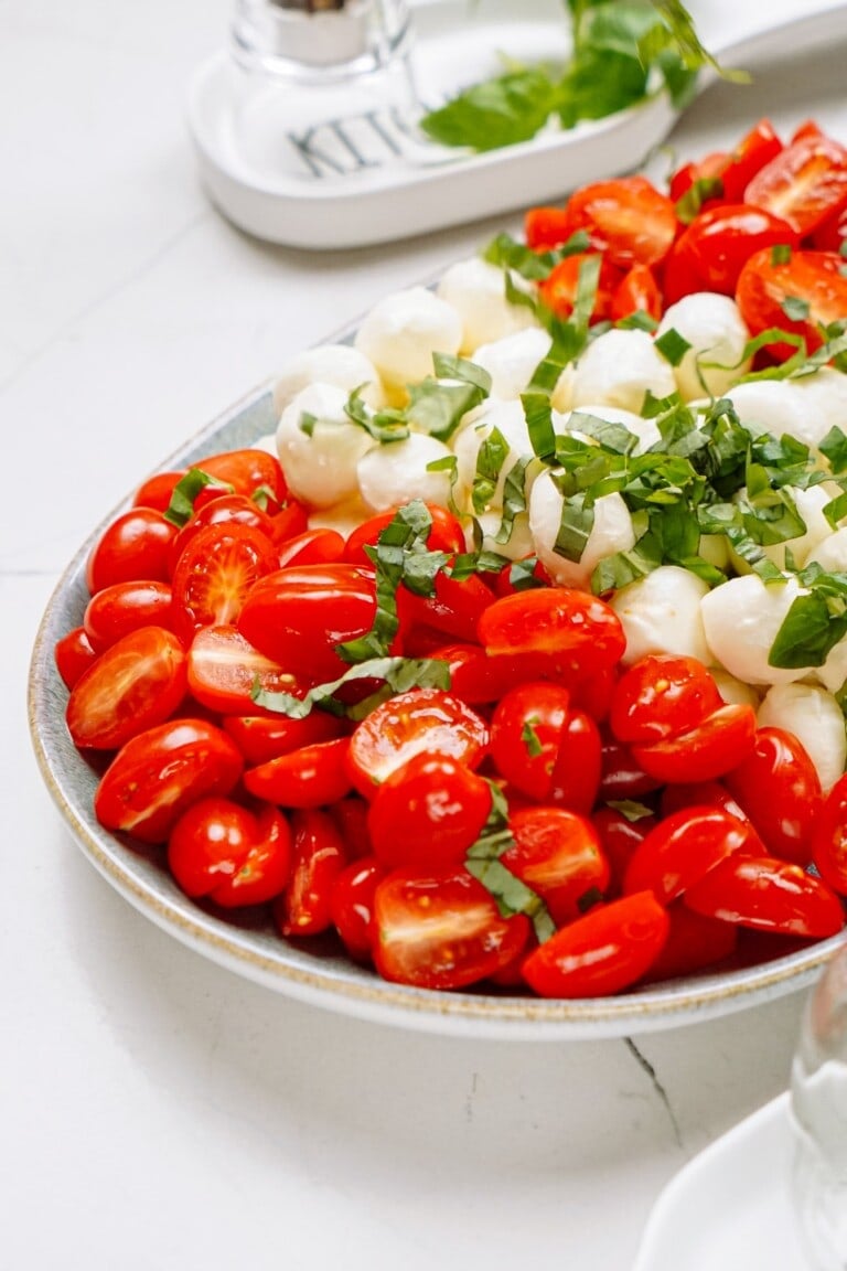 tomatoes, mozzarella and basil arranged on a plate