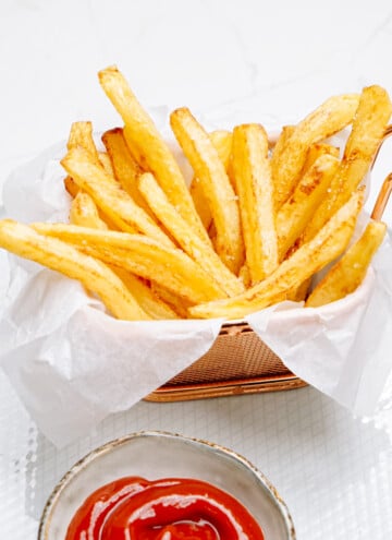 pomme frites arranged in wax paper with a little cup of ketchup