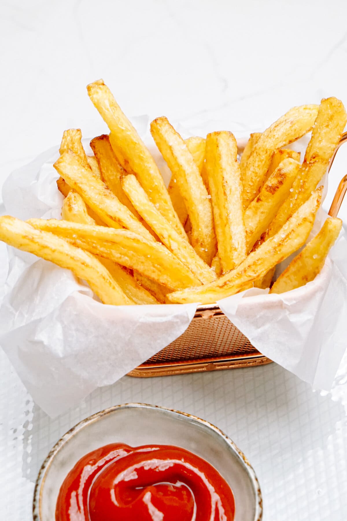 pomme frites arranged in wax paper with a little cup of ketchup