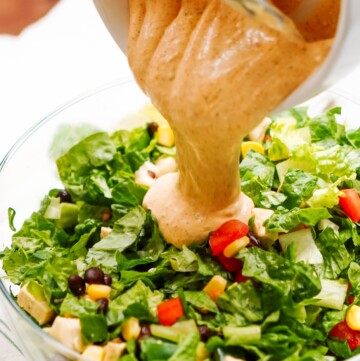 Pouring dressing on a southwest salad.