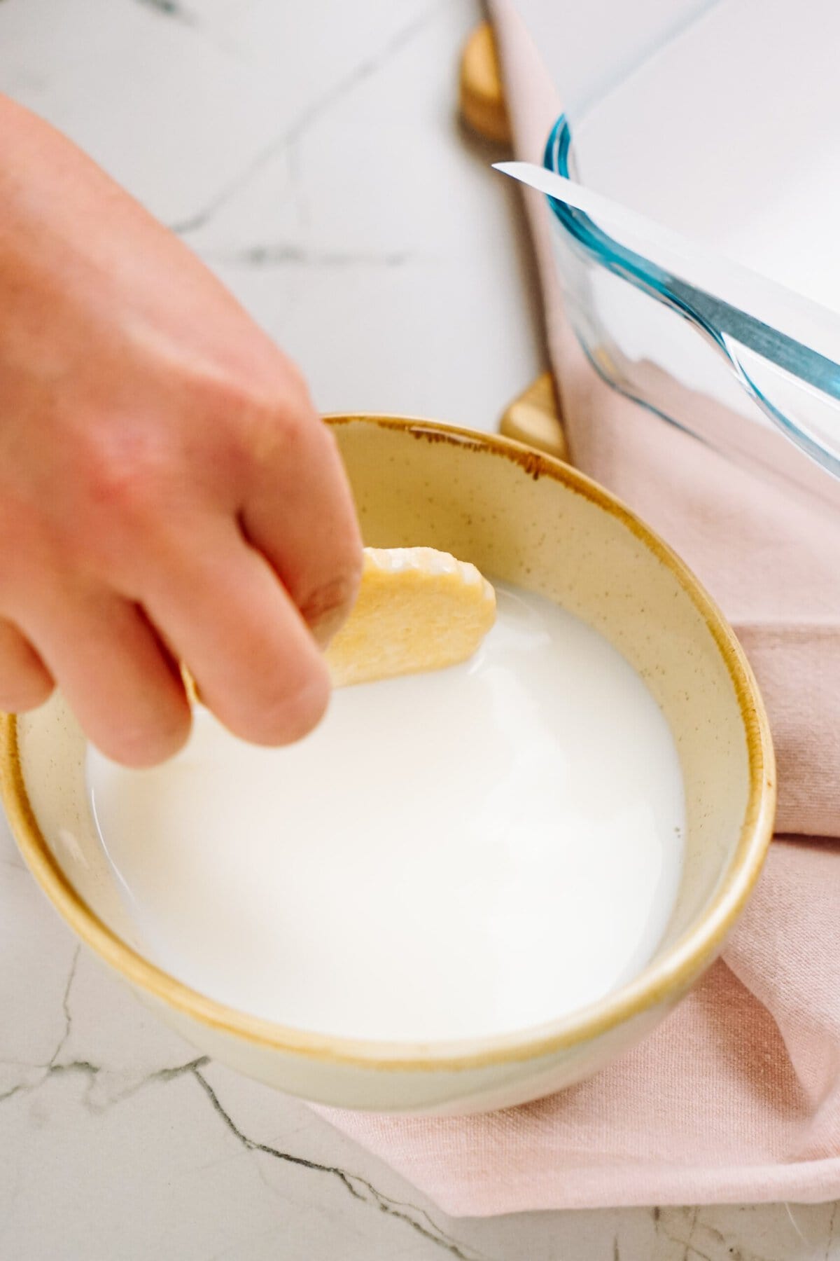 Dipping a cookie into a bowl of milk.