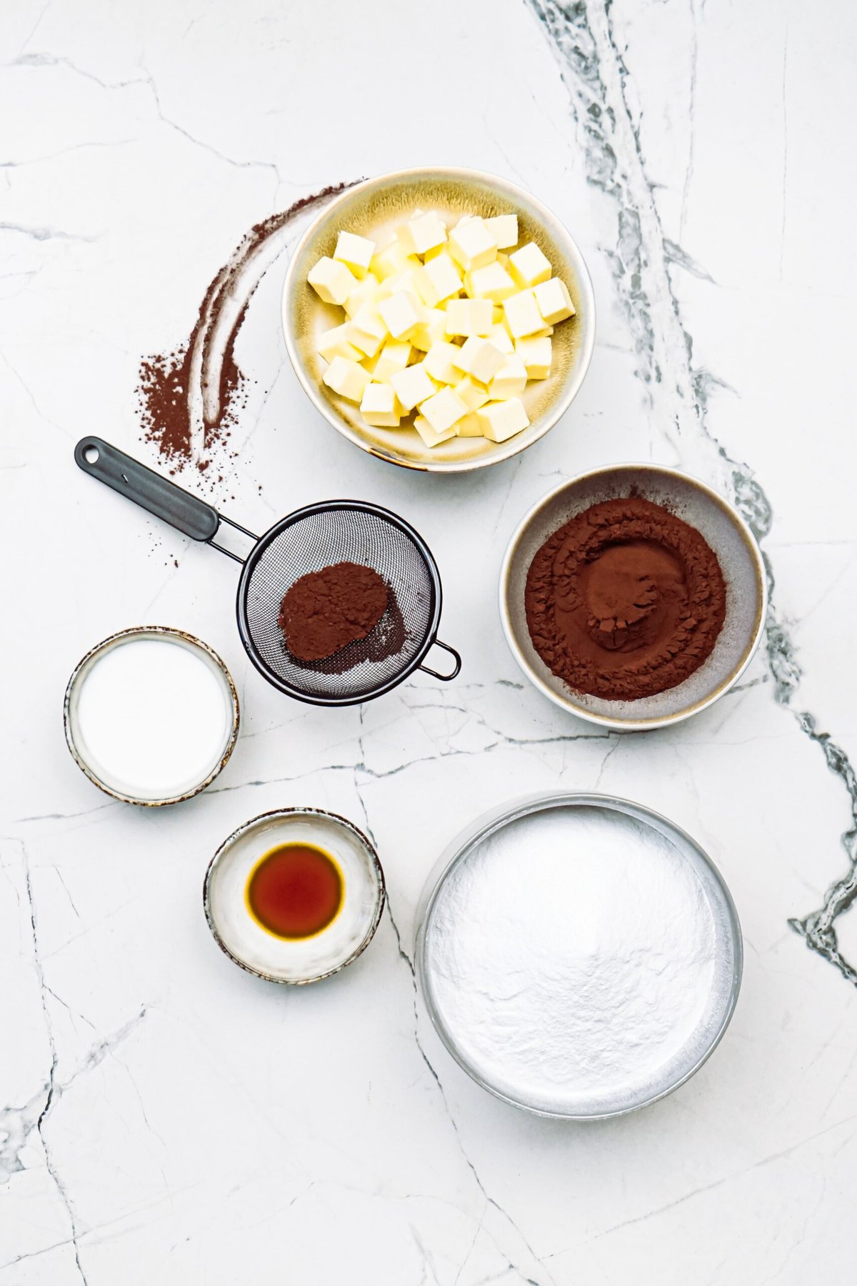 chocolate frosting ingredients on a marble counter top
