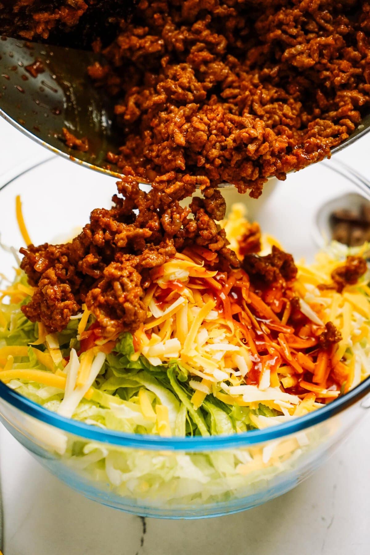 taco meat added to a bowl of taco salad
