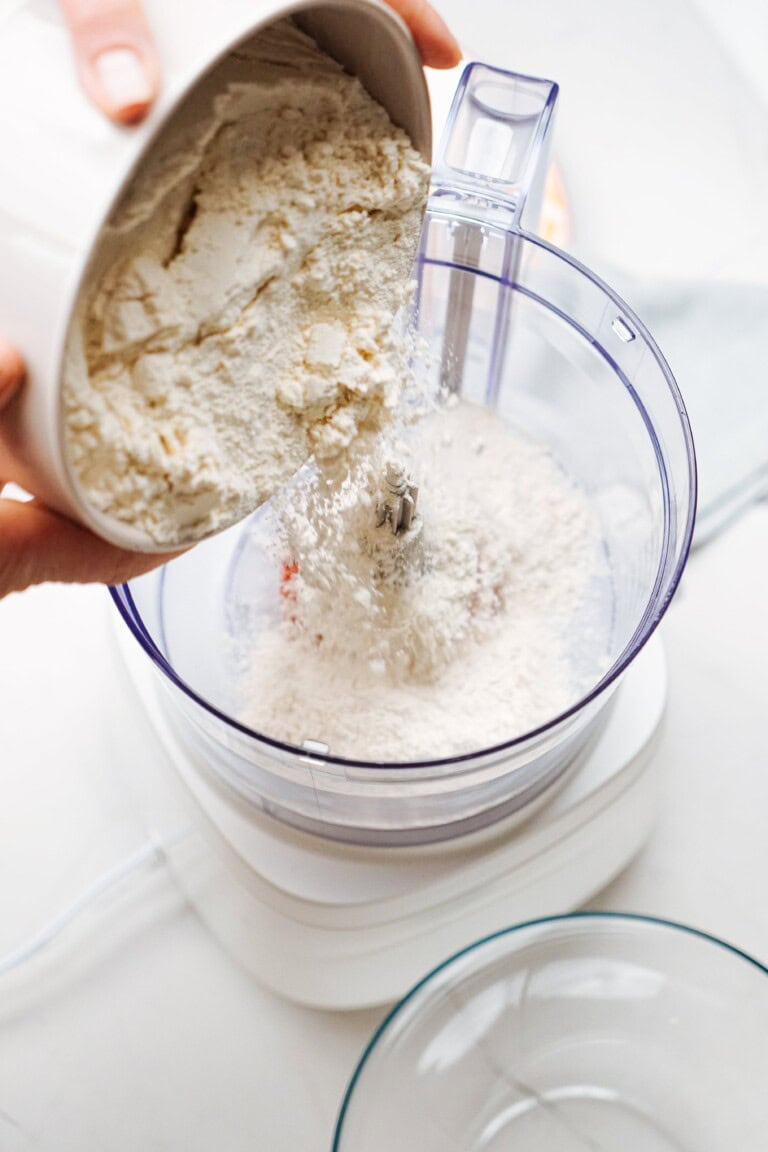 ingredients being added to a food processor bowl