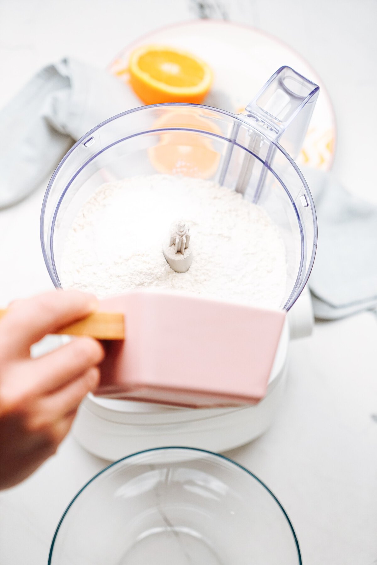 a person adding ingredients to a food processor to make scones