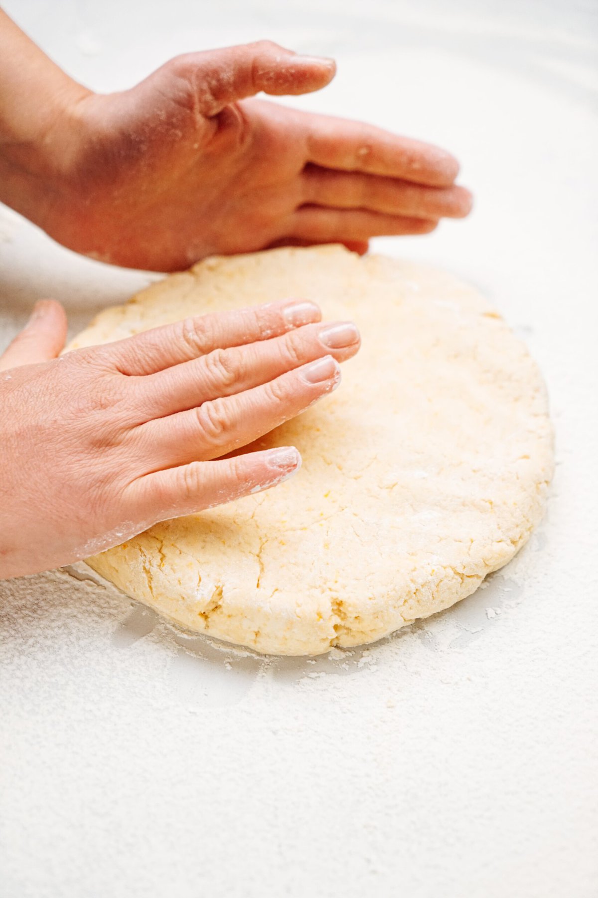 a person shaping scone dough into a circle